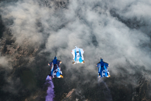 Formaci skydiverů vede Peter Sulzmann s elektrifikovaným wingsuitem. Wingsuit BMW.